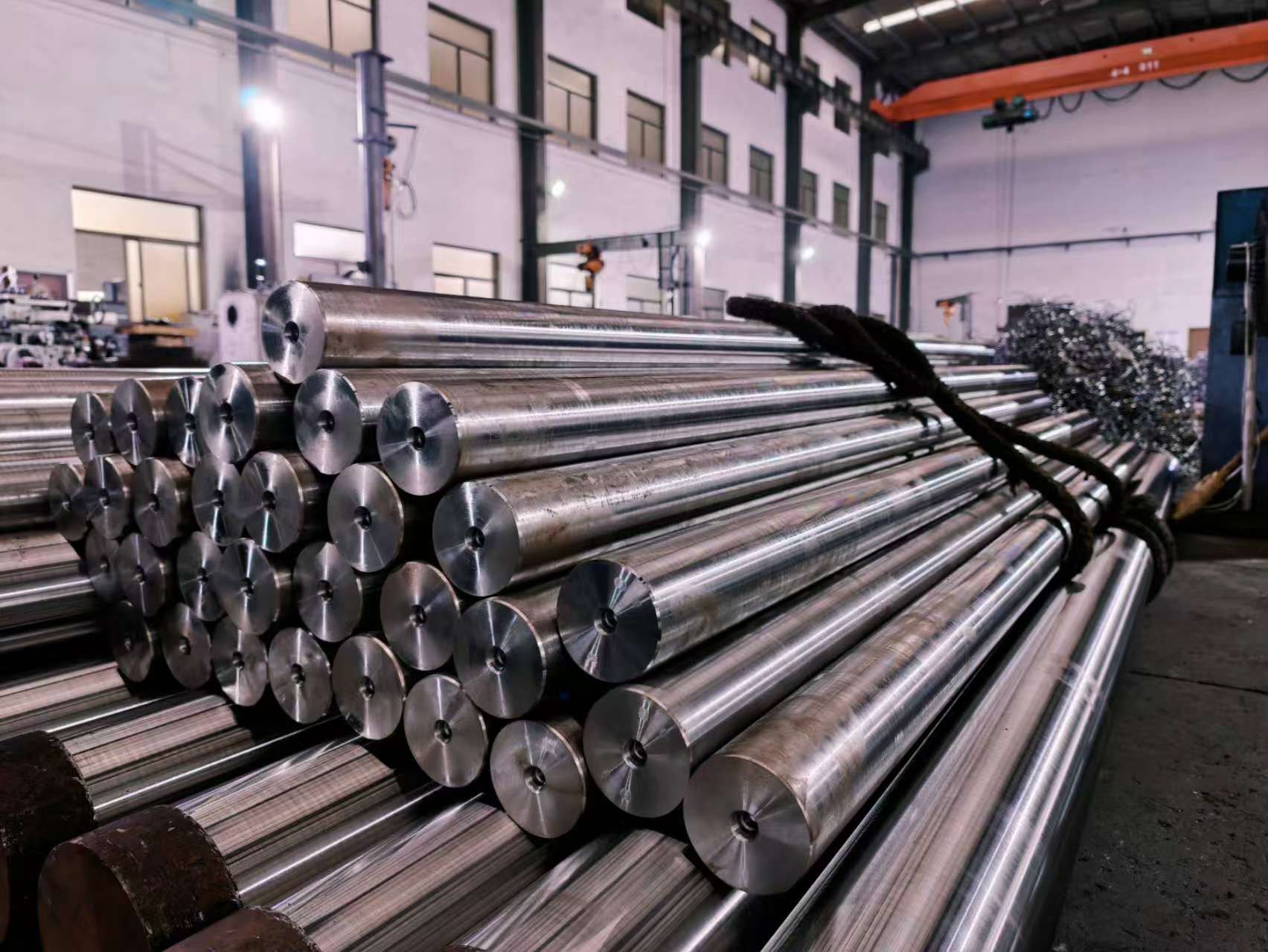 Machined steel shafts stacked inside the RJ workshop